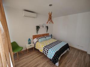 a bedroom with a bed and a green chair at Apartamento El dragoncillo del Cabo in Las Negras