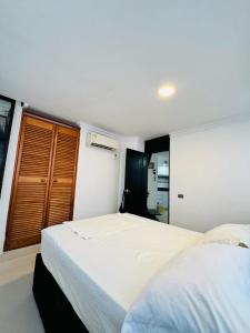 1 dormitorio con 2 camas blancas y ventana en Encantador apto en el Rodadero frente a la playa, en Santa Marta