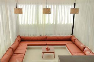 聖米格爾－杜戈斯托蘇的住宿－Casa Madá，客厅配有红色的沙发和桌子