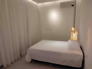 聖米格爾－杜戈斯托蘇的住宿－Casa Madá，卧室配有白色的床和灯