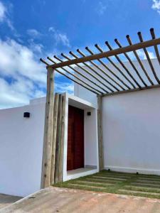 聖米格爾－杜戈斯托蘇的住宿－Casa Madá，白色的建筑,上面有木凉棚