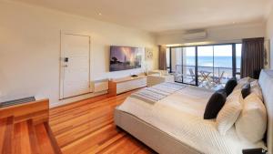 a bedroom with a bed with a view of the ocean at The Madsen Boutique Hotel in Penguin