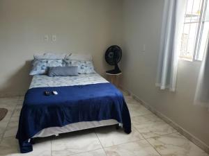 1 dormitorio con 1 cama con edredón azul y ventilador en Bessa 102, en João Pessoa
