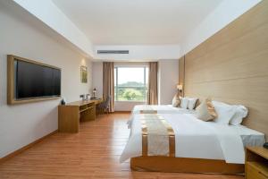 a hotel room with two beds and a flat screen tv at Phoenix Hill Hotel Dongguan - Golf Course Shop in Tiantangwei