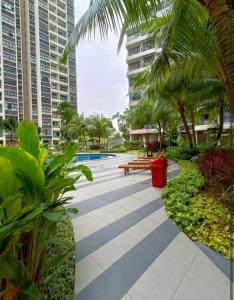 a walkway with a pool and palm trees and buildings at seaview beach 4-13pax CIQ 5mins johor bahru KSL MIDVALLEY in Johor Bahru