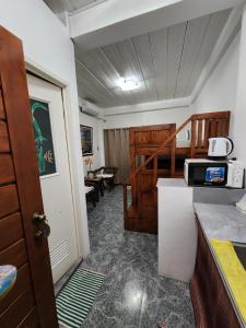 a room with a kitchen with a microwave and a staircase at ASHBURN'S TRANSIENT Bauang La Union - MOTORCYCLE PARKING ONLY in Lossoc
