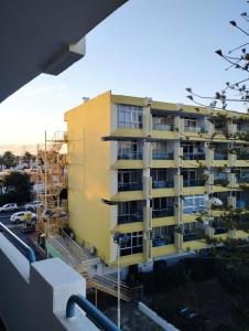 un edificio de apartamentos amarillo en construcción con andamios en Epicentro Maspalomas en Maspalomas