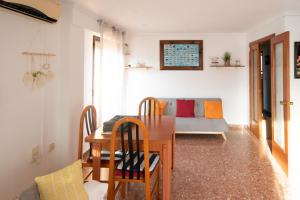 ein Wohnzimmer mit einem Tisch und einem Sofa in der Unterkunft An apartment in Xeraco with 3 bedrooms, located near beach and Gandia in Xeraco