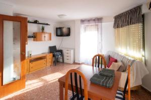 ein Wohnzimmer mit einem Sofa und einem Tisch in der Unterkunft An apartment in Xeraco with 3 bedrooms, located near beach and Gandia in Xeraco