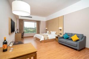a hotel room with a bed and a couch at Phoenix Hill Hotel Dongguan - Golf Course Shop in Tiantangwei +25 photos