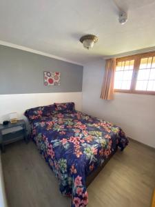 sypialnia z łóżkiem z narzutą kwiatową w obiekcie Epicentro Maspalomas w mieście Maspalomas