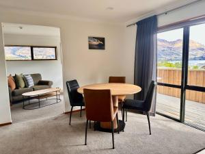 a living room with a table and chairs and a couch at Wanaka Springs Lodge in Wanaka