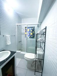 a bathroom with a toilet and a glass shower at Jobs Inn Jamaica in Montego Bay