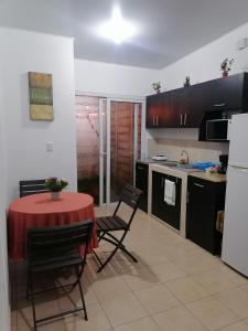 a kitchen with a red table and chairs in a room at Nenes Relax Home in Santa Ana