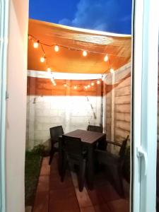 a patio with a table and chairs and lights at Nenes Relax Home in Santa Ana