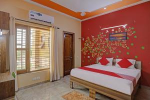 1 dormitorio con cama y pared roja en OYO Stay 130, en Noida