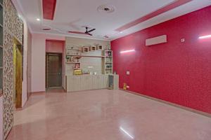 una habitación con una pared roja y una pared roja en OYO Stay 130, en Noida