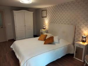 um quarto com uma cama branca com duas mesas de cabeceira em Gîte Harbouey, 4 pièces, 6 personnes - FR-1-584-36 