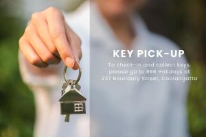 a hand holding a key chain with a house keychain at Calypso Tower Unit 807 in Gold Coast