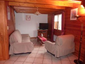 ein Wohnzimmer mit 2 Stühlen und einem TV in der Unterkunft Gîte Le Menil, 5 pièces, 5 personnes - FR-1-589-107 in Le Ménil