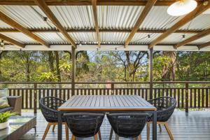 una mesa de madera y sillas en una terraza en Tranquil 2-Bed Family Home with Deck Among Trees, en Brisbane