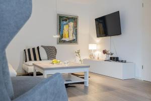 sala de estar con mesa y TV en fewo1846 - FlensBo II - komfortable Wohnung mit 2 Schlafzimmern und Terrasse, en Flensburg
