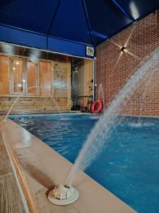 a water fountain in a swimming pool at شاليه أرياف Chalet Aryaf Yanbu in Yanbu