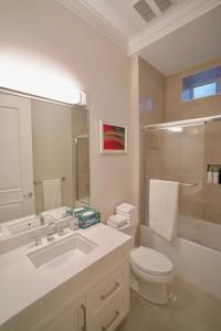 溫哥華的住宿－Balaclava Park House close UBC and Downtown，白色的浴室设有卫生间和水槽。