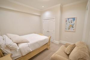 a bedroom with a bed and a couch in it at Balaclava Park House close UBC and Downtown in Vancouver