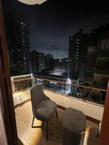 a chair sitting on a balcony with a view of a city at Space Hostel in Cairo