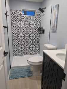 a bathroom with a shower and a toilet and a sink at Chic Parisian Guest House in Phoenix