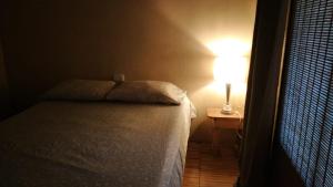 a bedroom with a bed and a lamp on a table at Casa Palos Verdes in Puerto Viejo
