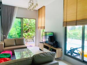 a living room with a couch and a television at In Town Pool Villa Krabi in Ban Khlong Chi Lat