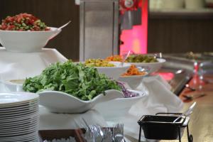 a buffet with bowls of food on a table at Neve Shalom Hotel in Neve Shalom