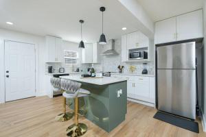 a kitchen with white cabinets and a large refrigerator at Oasis S-Kape near ATL airport! in Atlanta