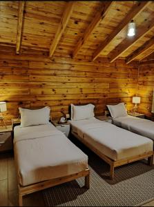 - 2 lits dans une chambre dotée de murs en bois dans l'établissement شاليه أرياف Chalet Aryaf Yanbu, à Yanbu