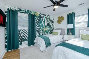 a bedroom with two beds and a window with green curtains at Oasis S-Kape near ATL airport! in Atlanta