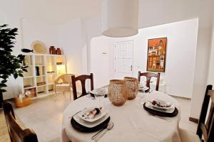 a dining room with a table with plates and glasses at Acacias Home Arrecife in Arrecife
