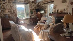 a living room with chairs and a fireplace at Le Mas des Mûriers en Cévennes gardoises in Gagnières