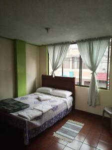 1 dormitorio con cama y ventana en MI CASITA VERDE, en Baños