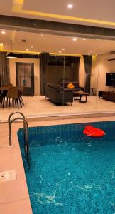 een zwembad in een kamer met een woonkamer bij شاليهات درة بارك الشقيق in Ash Shuqayq