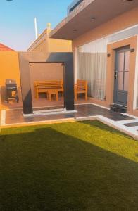 a patio with a wooden table and a lawn at شاليهات درة بارك الشقيق in Ash Shuqayq