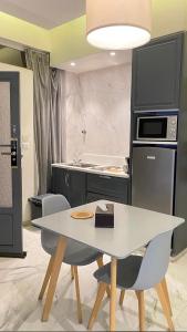 a kitchen with a white table and a stove at شاليهات درة بارك اقتصادية الشقيق in Ash Shuqayq