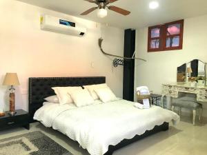 a bedroom with a bed with a fan and a desk at Luna Nueva Casa de Huéspedes in Ríohacha