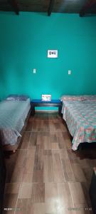 2 camas en una habitación con una pared azul en Estanislao López 127 en Puerto Iguazú