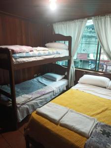 a room with three bunk beds and a window at MI CASITA VERDE in Baños