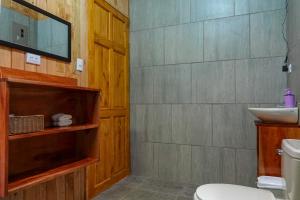 y baño con aseo y lavamanos. en Cabaña Indira, en Monteverde