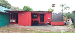 a man standing in front of a red house at Estanislao López 127 in Puerto Iguazú