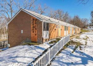 a building with a fence in the snow at Studio w/ King Bed near Dwtn in Rochester