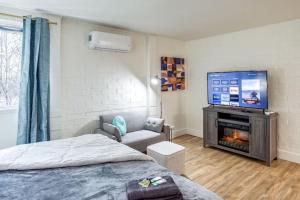 a bedroom with a bed and a flat screen tv at Studio w/ King Bed near Dwtn in Rochester